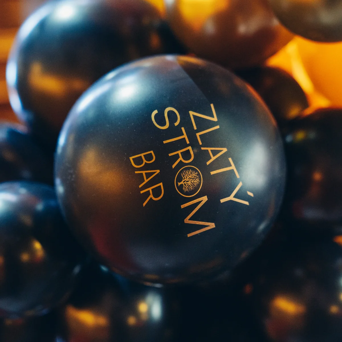 Silvestr ve Zlatém Stromě – černé balonky s logem Zlatý Strom Bar